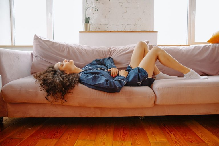 A bloated woman laying on the couch.