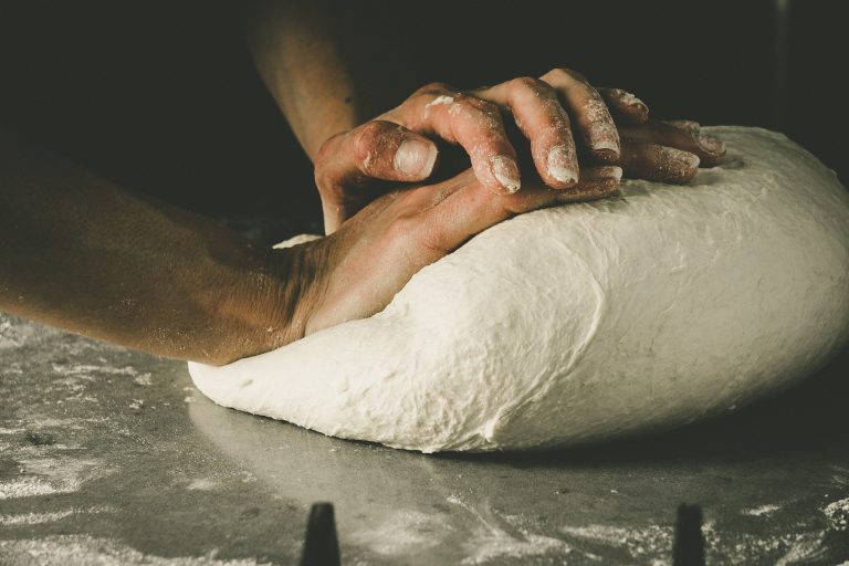 Someone making a pizza crust.